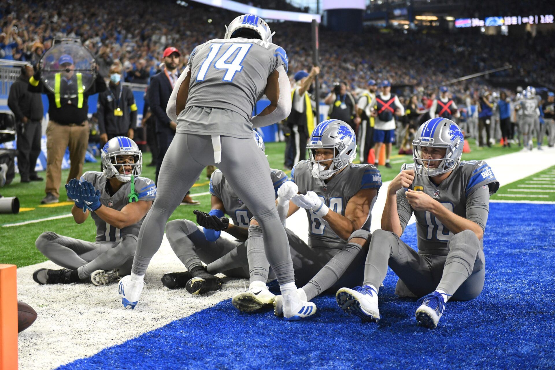Detroit Lions WR Amon-Ra St. Brown (14) celebrates with teammates after a touchdown.