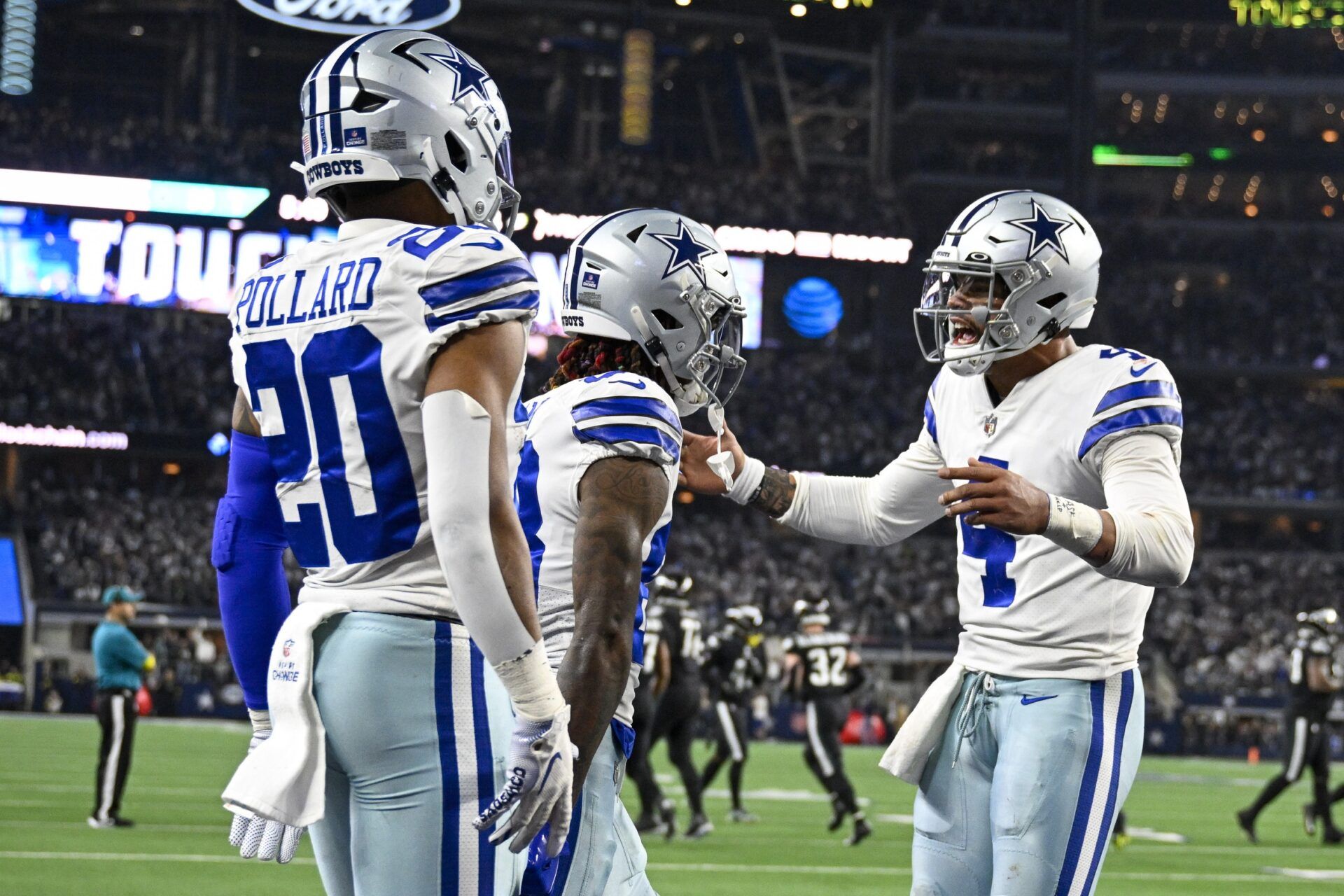 Dallas Cowboys QB Dak Prescott (4), WR CeeDee Lamb (88), and RB Tony Pollard (20) celebrate after a touchdown.