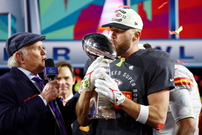 Travis Kelce (87) kisses the Vince Lombardi Trophy after winning Super Bowl LVII against the Philadelphia Eagles at State Farm Stadium.