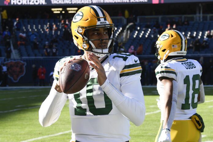 Green Bay Packers QB Jordan Love (10) warms up on the sidelines.