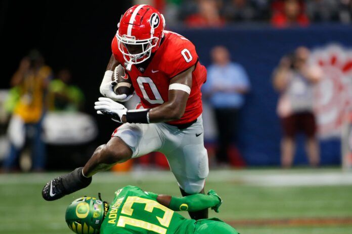 Tight end Darnell Washington (0) leaps over an Oregon defender.