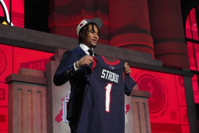 Quarterback C.J. Stroud poses for pictures at the 2023 NFL Draft with his jersey after being selected by the Houston Texans.