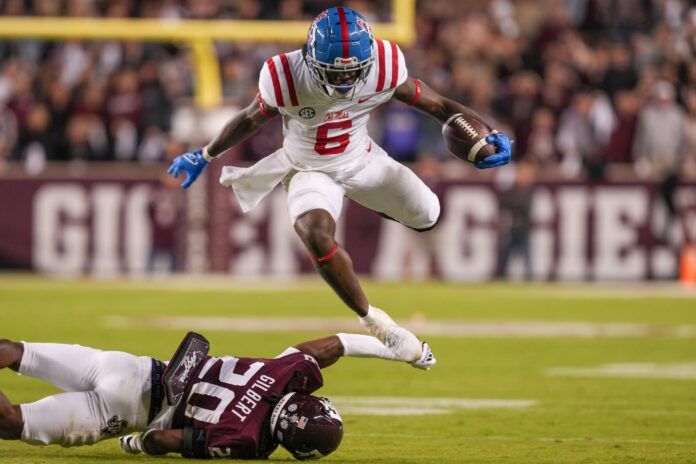 Running back Zach Evans (6) jumps over a Texas A&M defender.