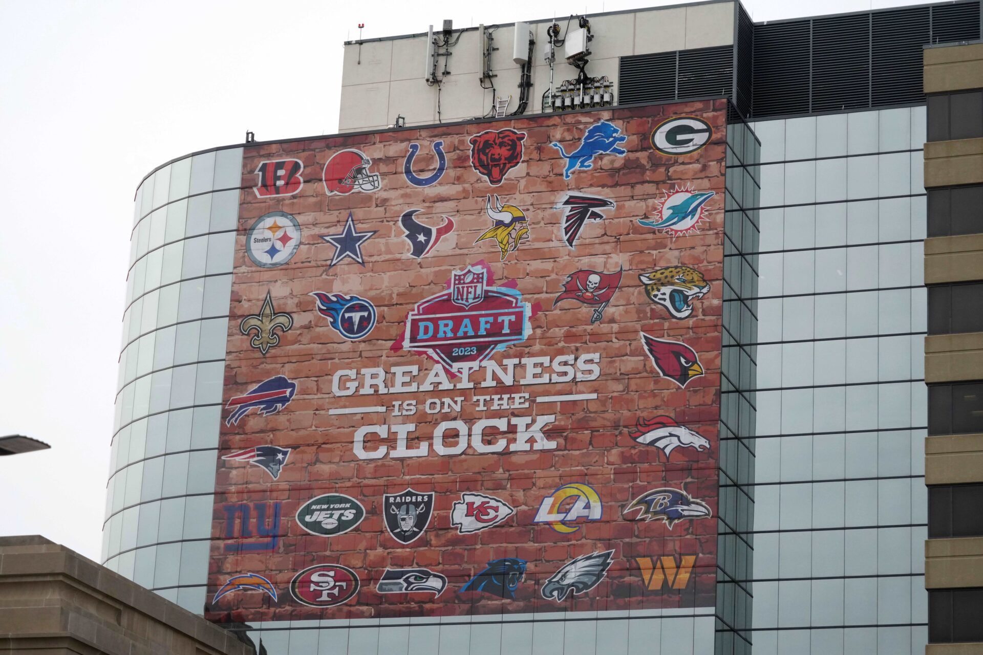 A sign in downtown Kansas City promoting the 2023 NFL Draft with team logos.
