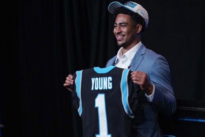 Quarterback Bryce Young holds up his jersey shortly after being selected by the Carolina Panthers.