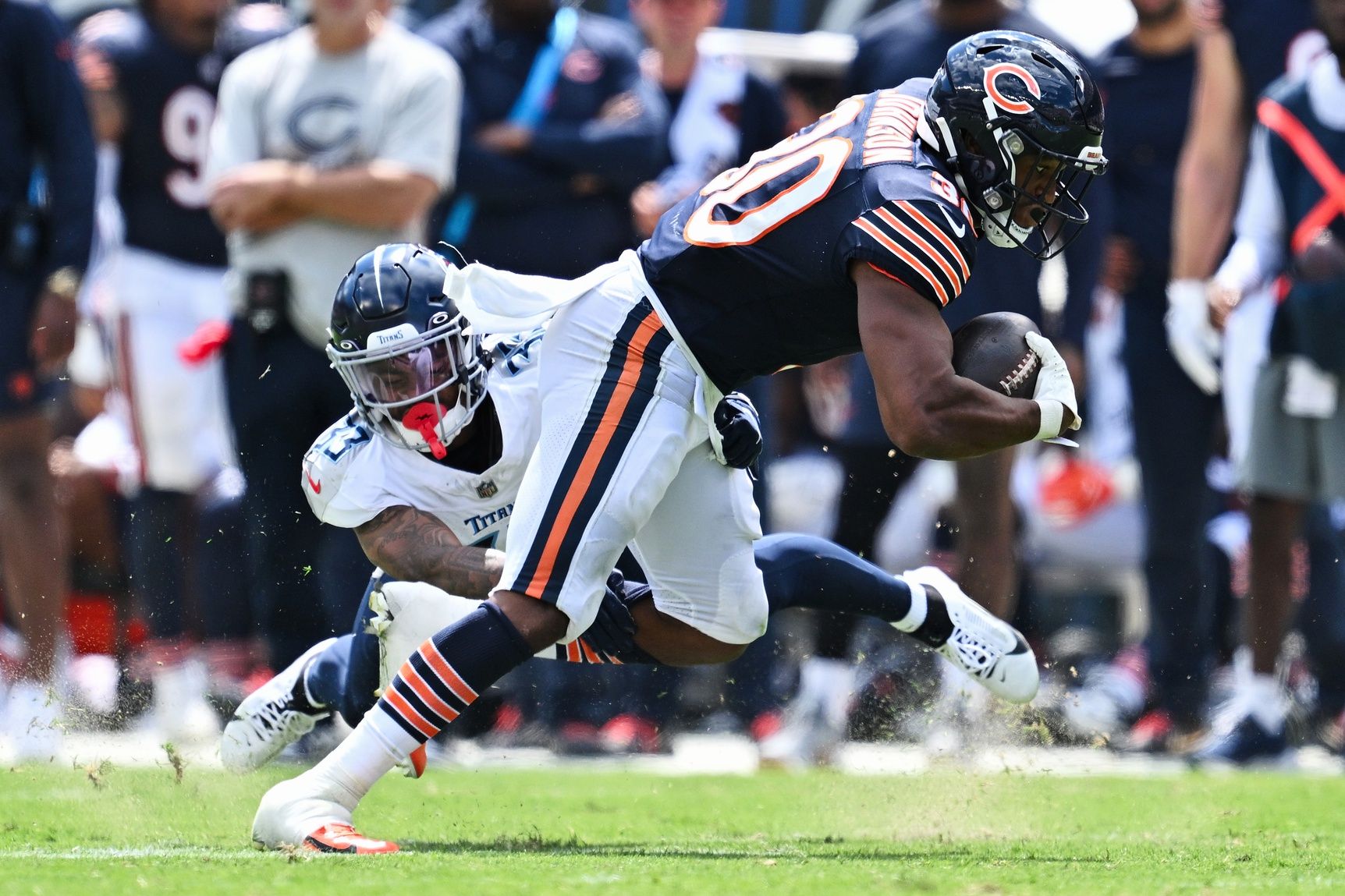 Roschon Johnson (30) is tackled by Tennessee Titans defensive back Eric Garror (33) after a short gain in the second half at Soldier Field.