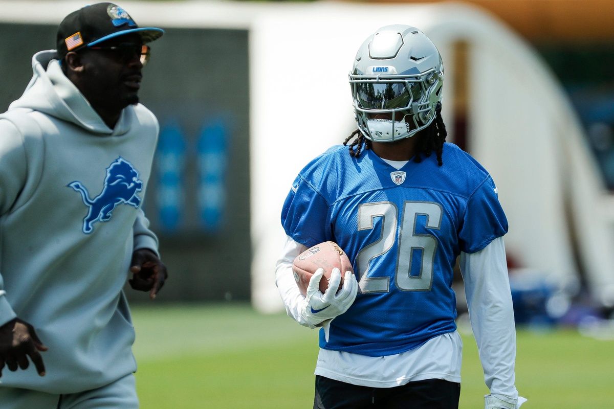 Jahmyr Gibbs, right, practices next to running backs coach Scottie Montgomery during minicamp at in Allen Park.