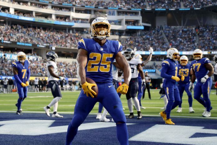 Joshua Kelley (25) celebrates after scoring a touchdown during the first quarter against the Tennessee Titans at SoFi Stadium.