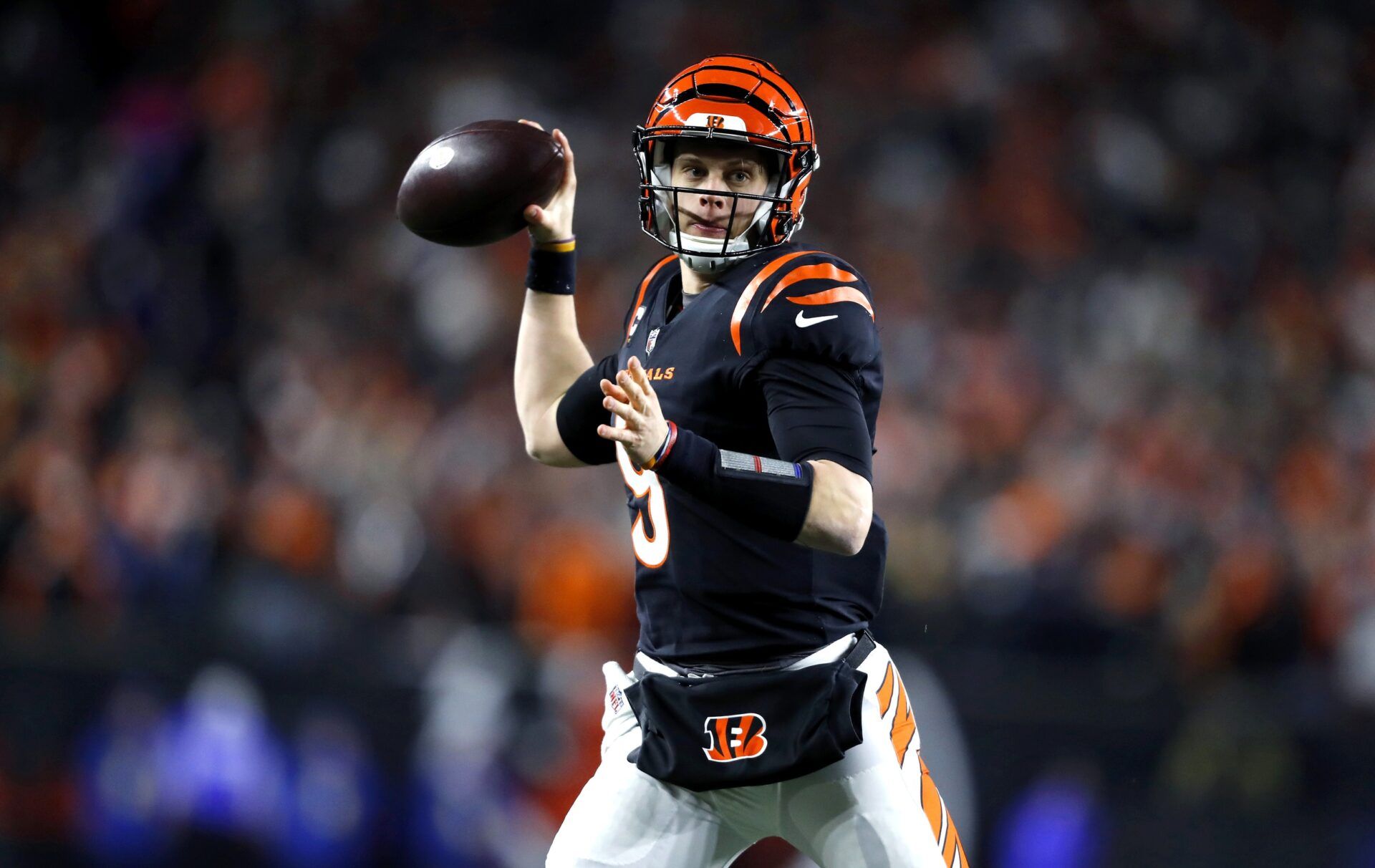 Joe Burrow (9) throws a pass to convert on a two-point conversion during the second half against the Baltimore Ravens in a wild card game at Paycor Stadium.