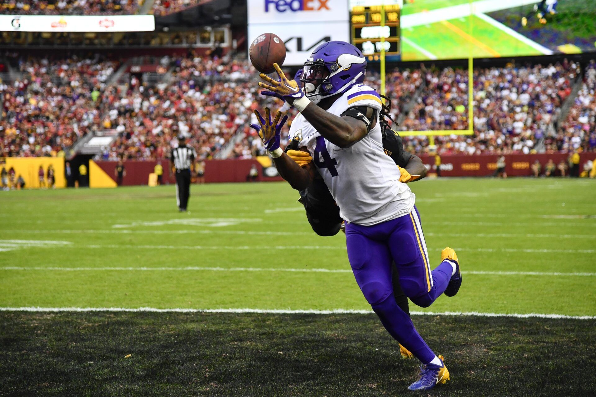 Dalvin Cook (4) catches a touchdown pass over Washington Commanders safety Kamren Curl (31) during the second half at FedExField.