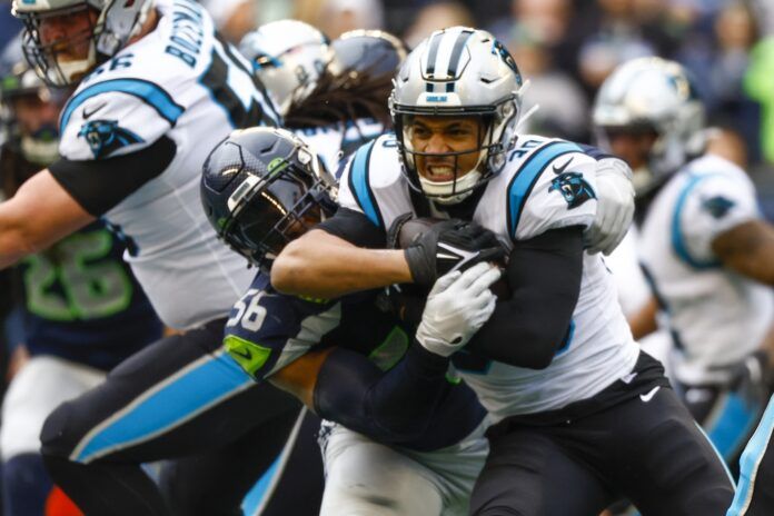 Jordyn Brooks (56) tackles Carolina Panthers running back Chuba Hubbard (30) on a rushing attempt during the first quarter at Lumen Field.