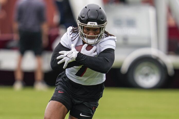 Bijan Robinson (7) runs during a drill during minicamp at IBM Performance Field.