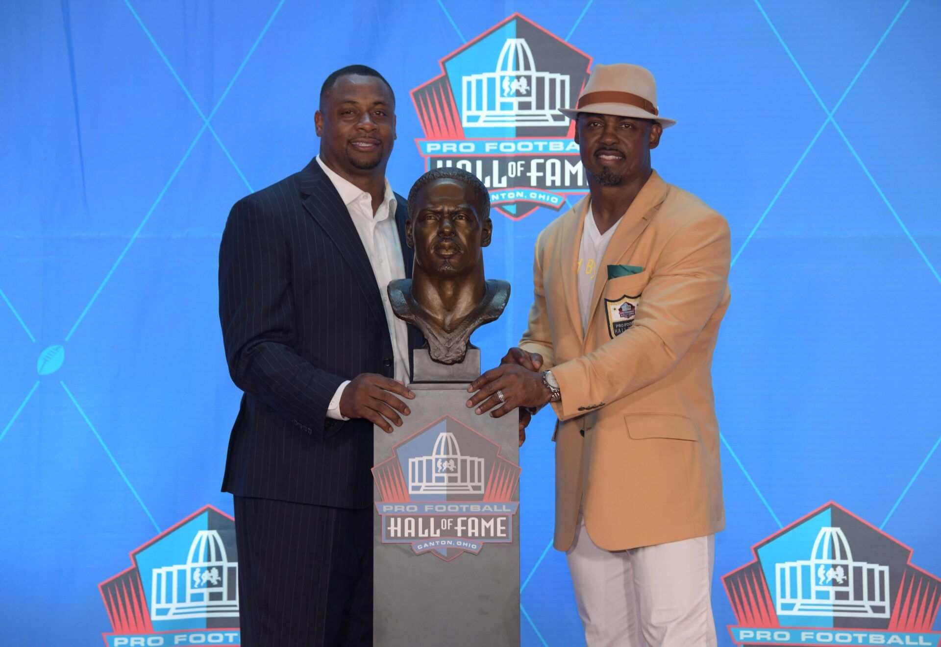 Philadelphia Eagles and Denver Broncos former safety Brian Dawkins (right) and presenter Troy Vincent pose with bust during the Pro Football Hall of Fame Enshrinement Ceremony at Tom Bensen Stadium.