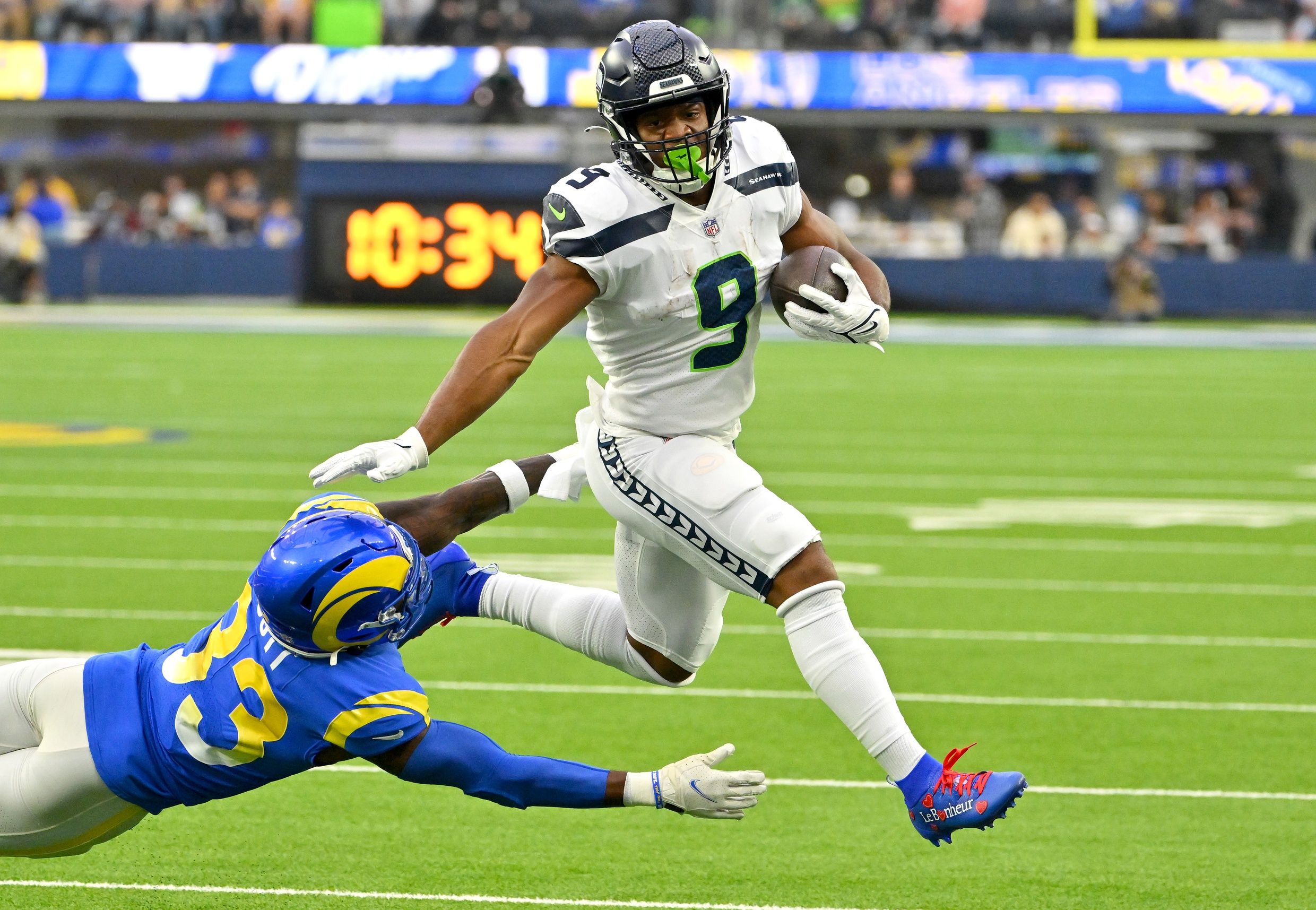 Kenneth Walker III (9) runs past Los Angeles Rams safety Nick Scott (33) for a first down in the first half at SoFi Stadium.