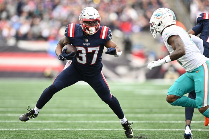 Damien Harris (37) rushes against Miami Dolphins safety Jevon Holland (8) during the first half at Gillette Stadium.