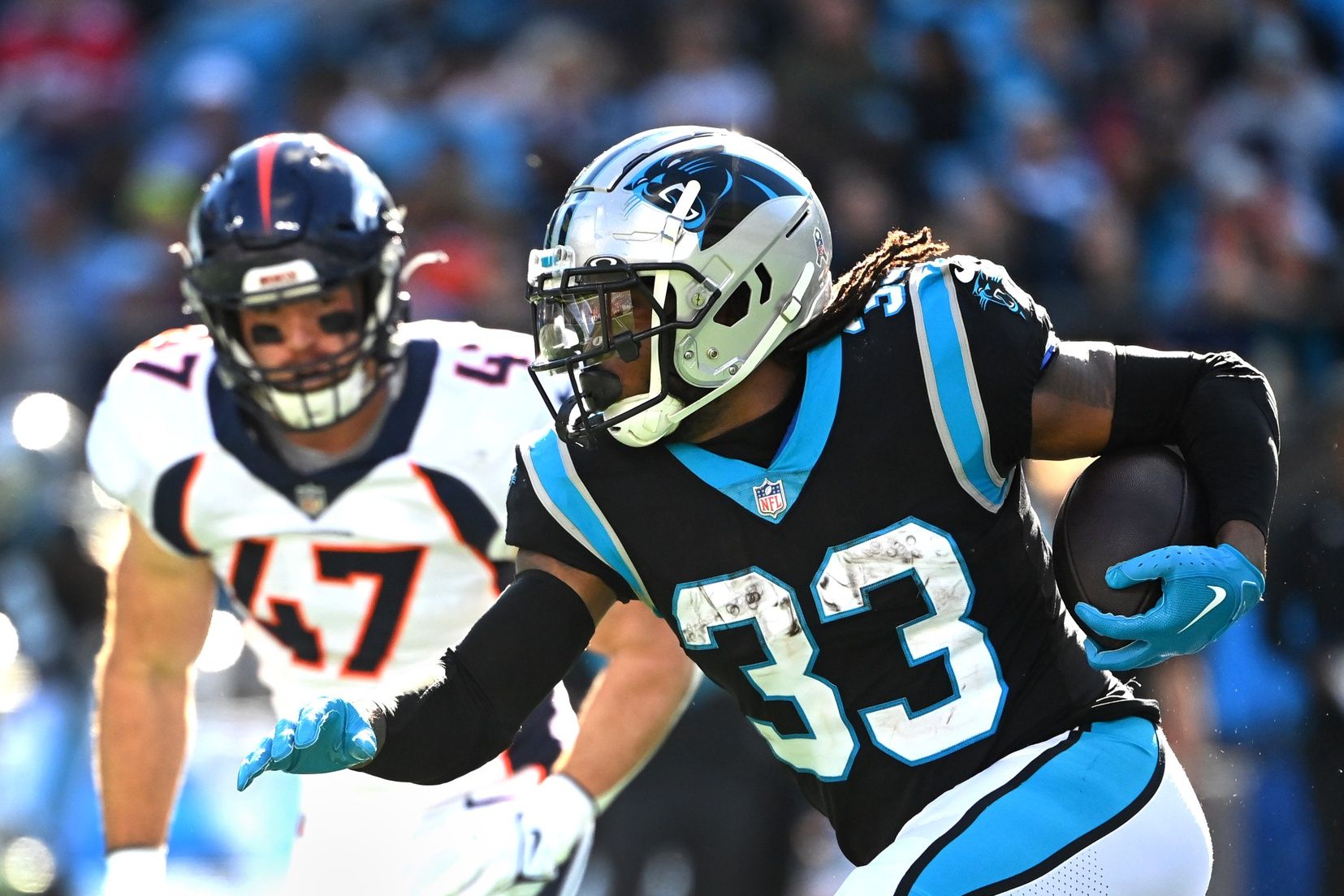 D'Onta Foreman (33) runs with the ball as Denver Broncos linebacker Josey Jewell (47) defends in the second quarter at Bank of America Stadium.