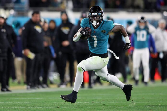 Travis Etienne Jr. (1) runs during the fourth quarter of a wild card game against the Los Angeles Chargers at TIAA Bank Field.