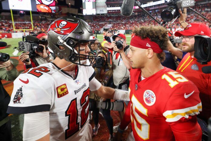 Quarterbacks Tom Brady (12) and Patrick Mahomes (15) meet after a game.