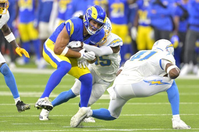 Los Angeles Rams WR Puka Nacua (17) holds on to the ball against the Chargers.