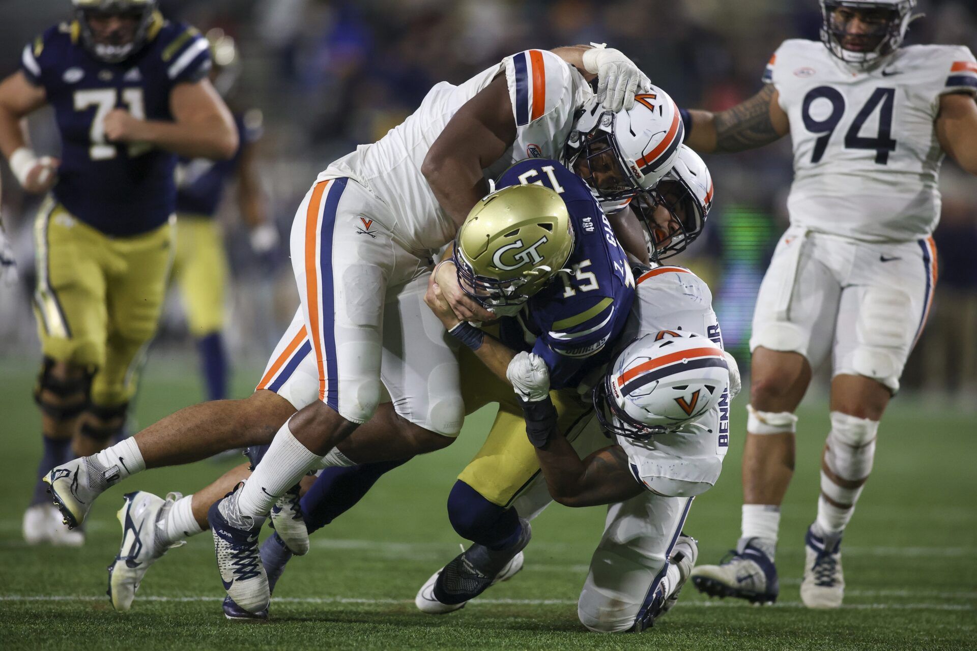 Zach Gibson (15) is sacked by Virginia Cavaliers defensive end Paul Akere (1) and defensive end Cam Butler (82) and bandit Chico Bennett Jr. (15) in the second half at Bobby Dodd Stadium.