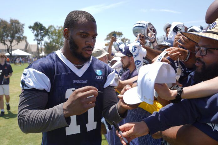 Micah Parsons (11) signs autographs during training camp at the River Ridge Fields.