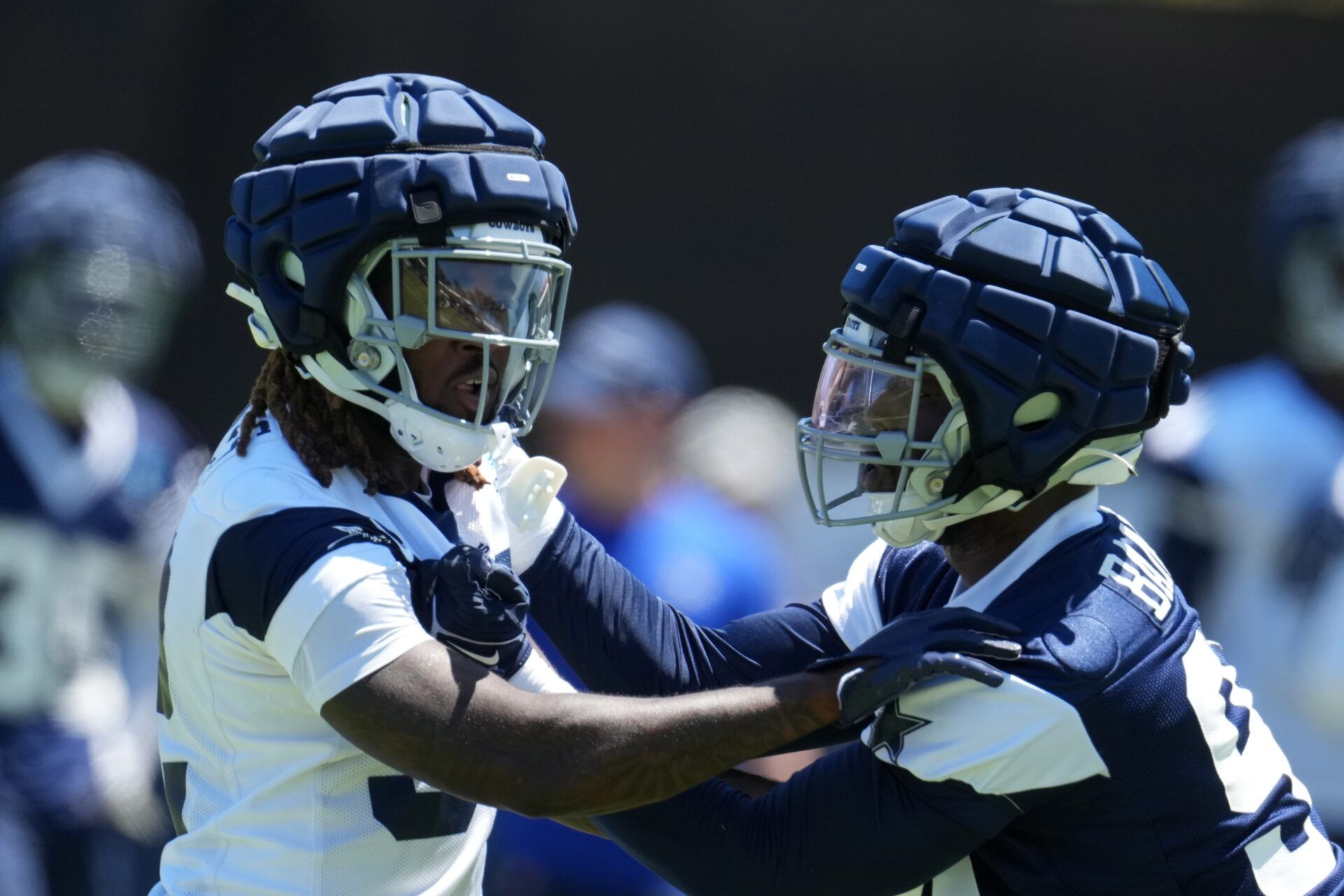 Ronald Jones (left) and defensive end Ben Banogu wear Guardian helmet caps during training camp at Marriott Residence Inn-River Ridge Playing Fields.
