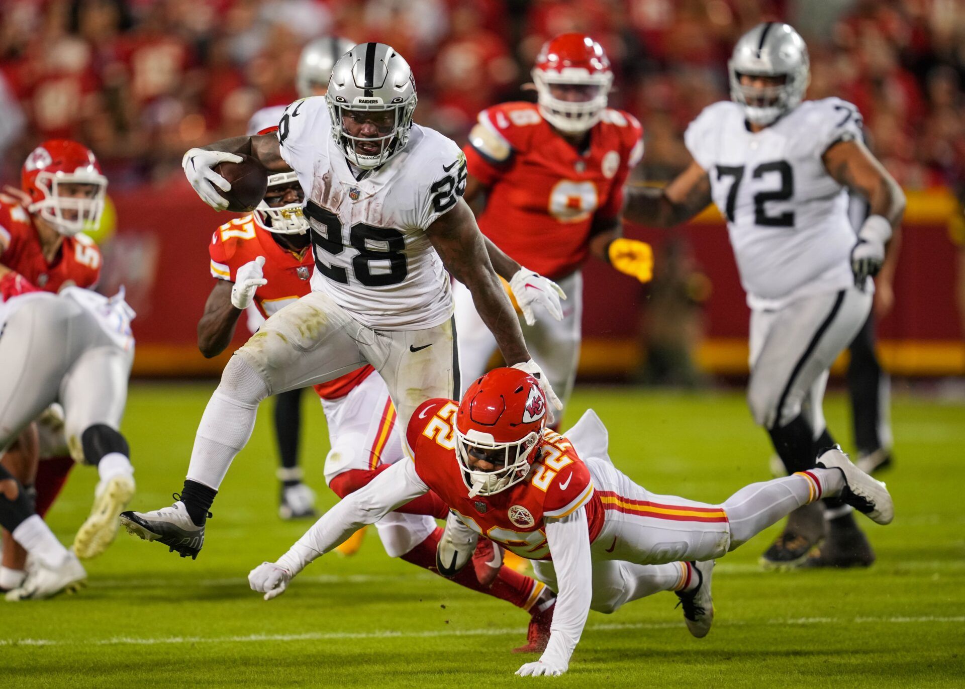 Las Vegas Raiders RB Josh Jacobs (28) attempts to break tackles against the Kansas City Chiefs.