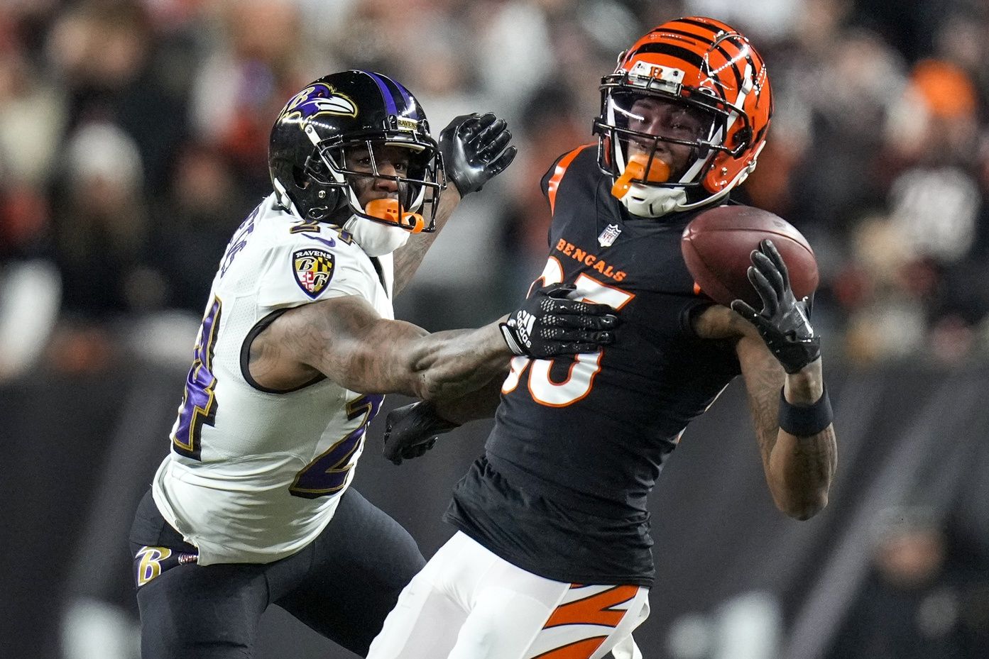 Baltimore Ravens CB Marcus Peters (24) attempts to break up a pass intended for Cincinnati Bengals WR Tee Higgins (85).