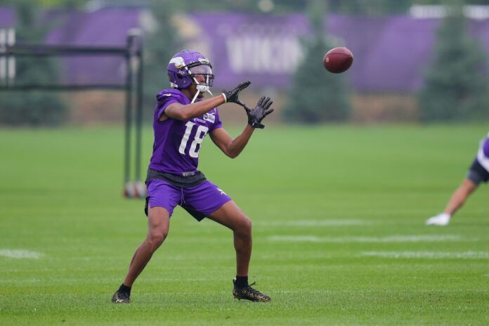 Justin Jefferson (18) catches a pass at training camp at TCO Performance Center.