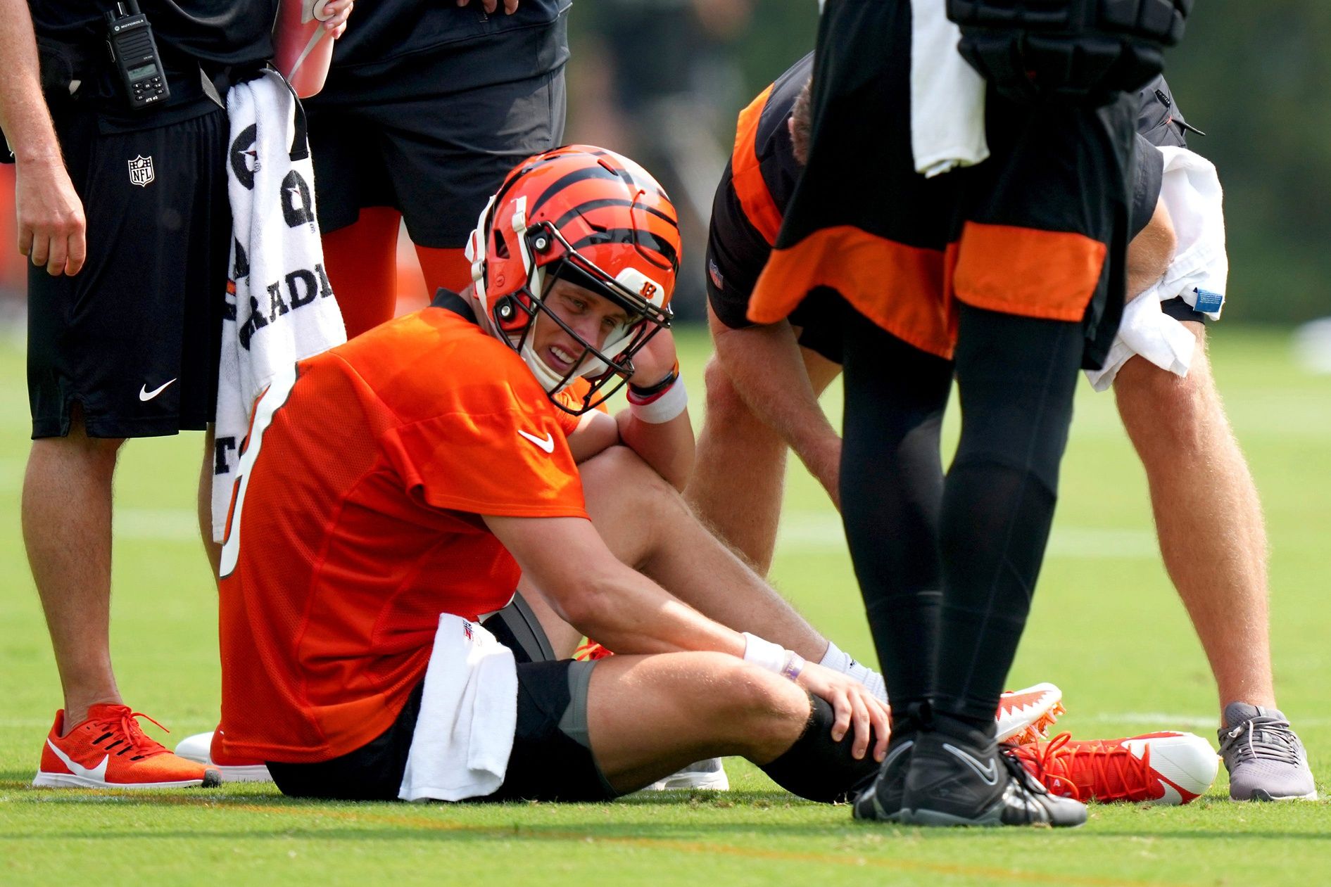 Joe Burrow (9) grabs his calf after an injury on a scramble play during NFL football training camp.