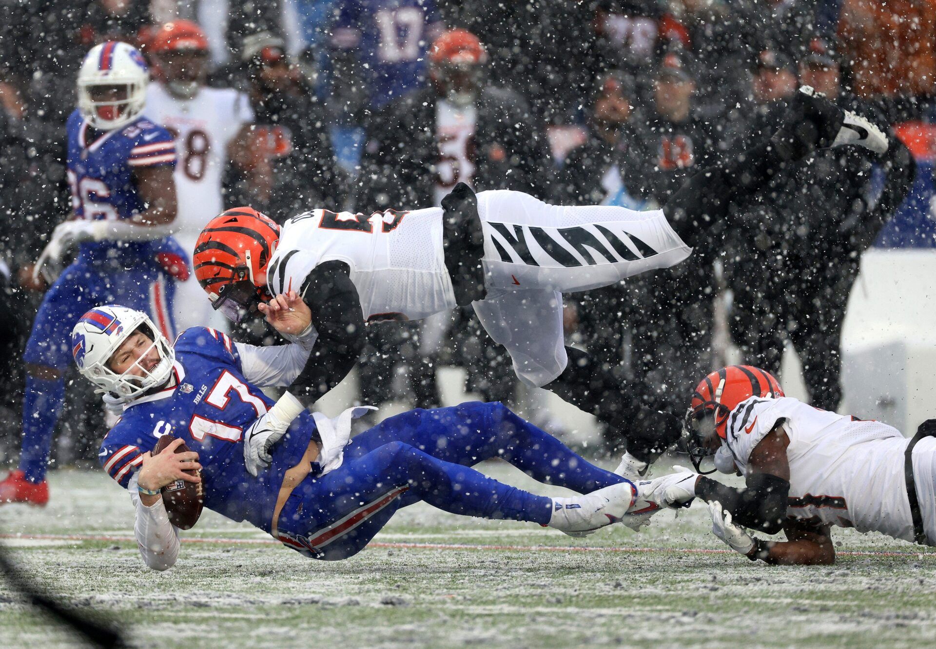 Buffalo Bills QB Josh Allen takes a big hit from a Cincinnati Bengals defender after running for a first down.