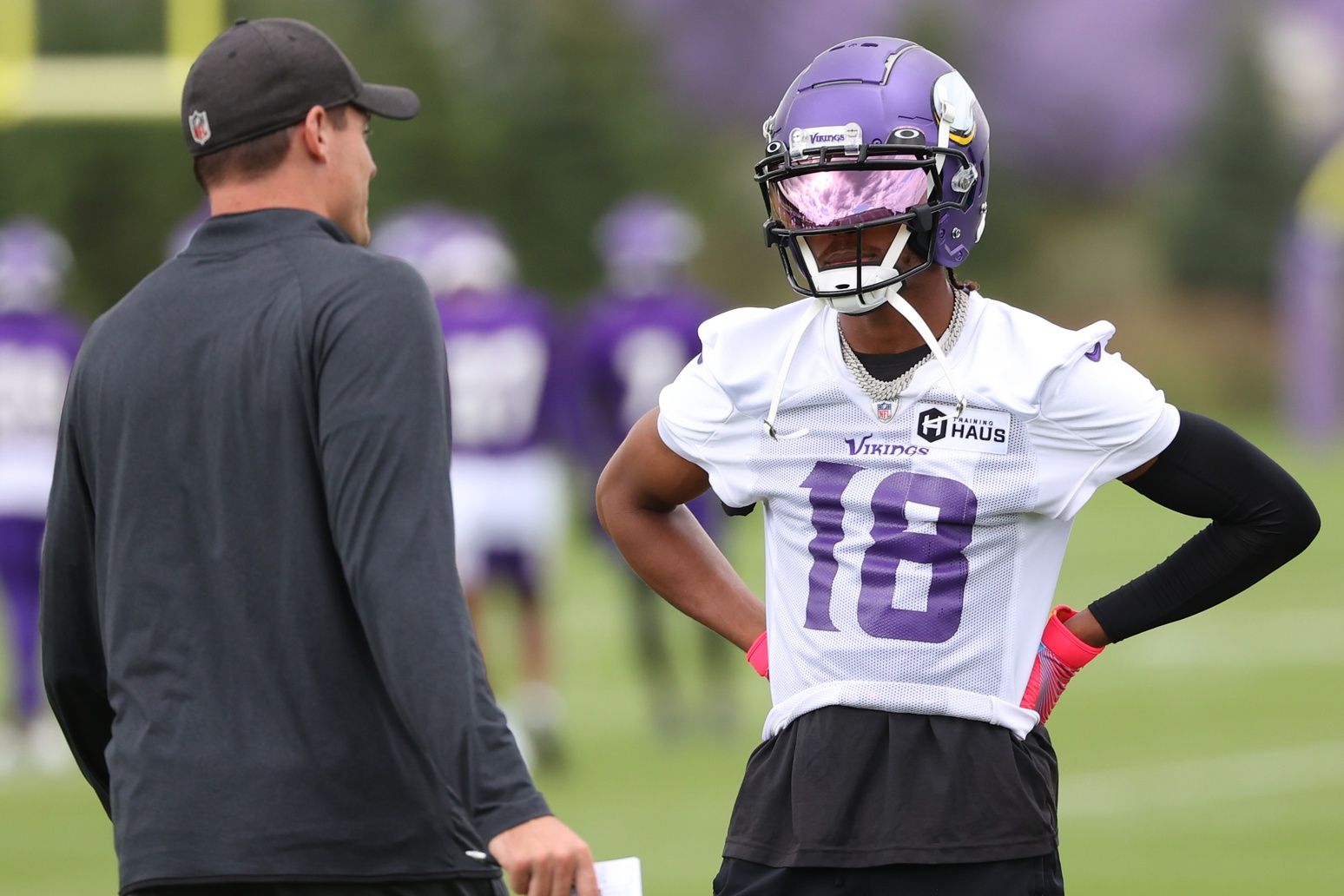 Kevin O'Connell and wide receiver Justin Jefferson (18) talk during training camp at TCO Performance Center.