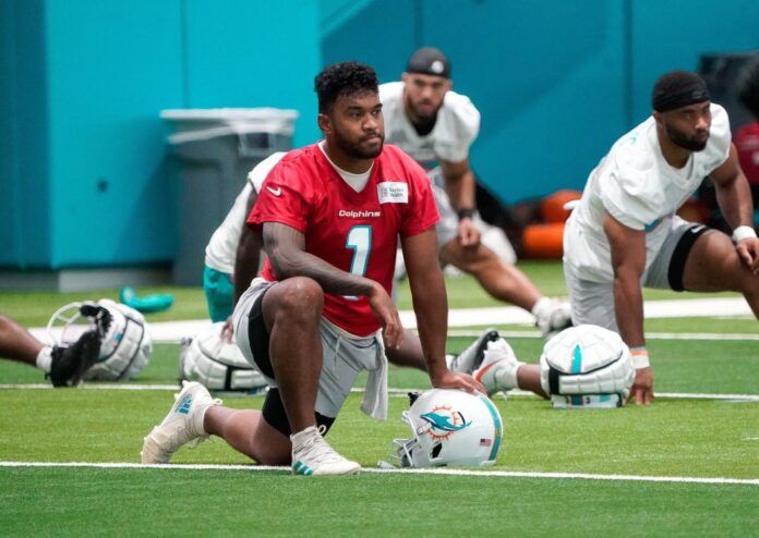 Miami Dolphins QB Tua Tagovailoa (1) on a knee during the team's first practice in training camp.