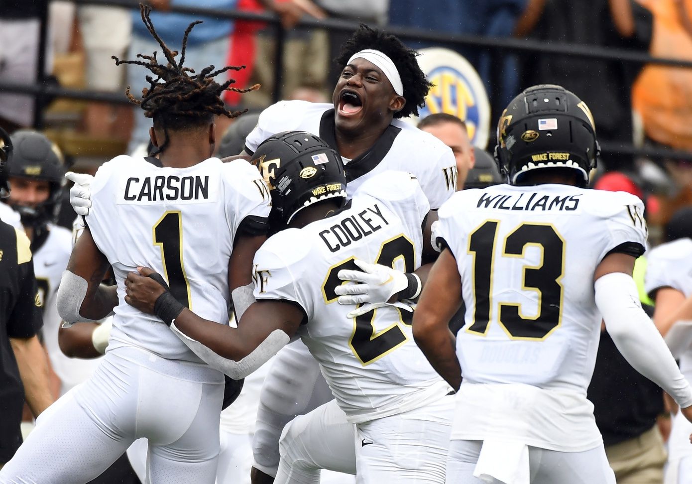 Malik Mustapha (3) celebrates with running back Quinton Cooley (28) and Wake Forest Demon Deacons defensive back Caelen Carson (1) after a touchdown during the second half against the Vanderbilt Commodores at FirstBank Stadium.