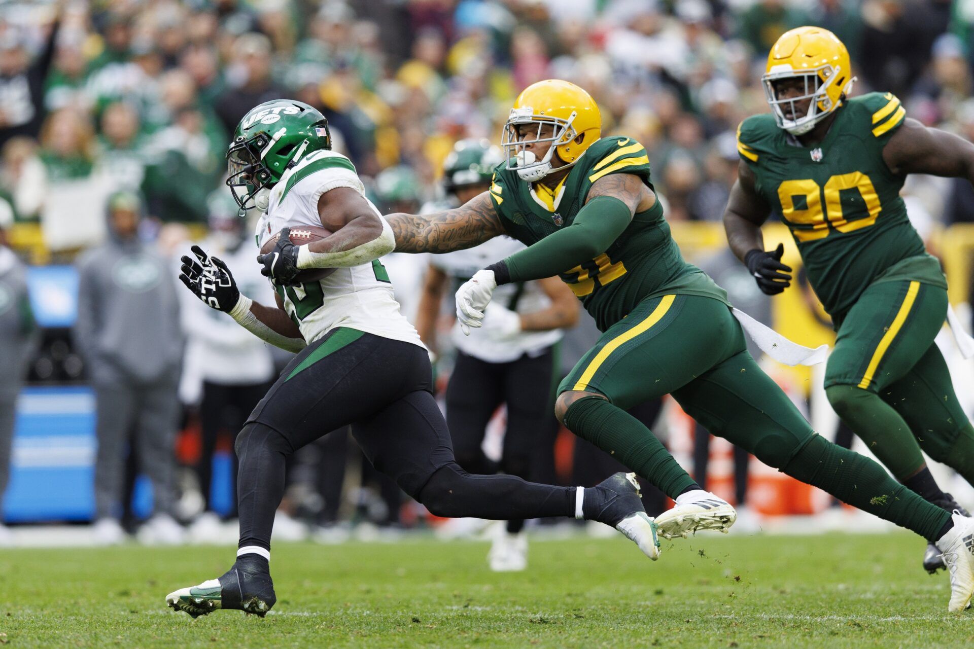 New York Jets RB Breece Hall (20) tries to get away from Green Bay Packers defenders.