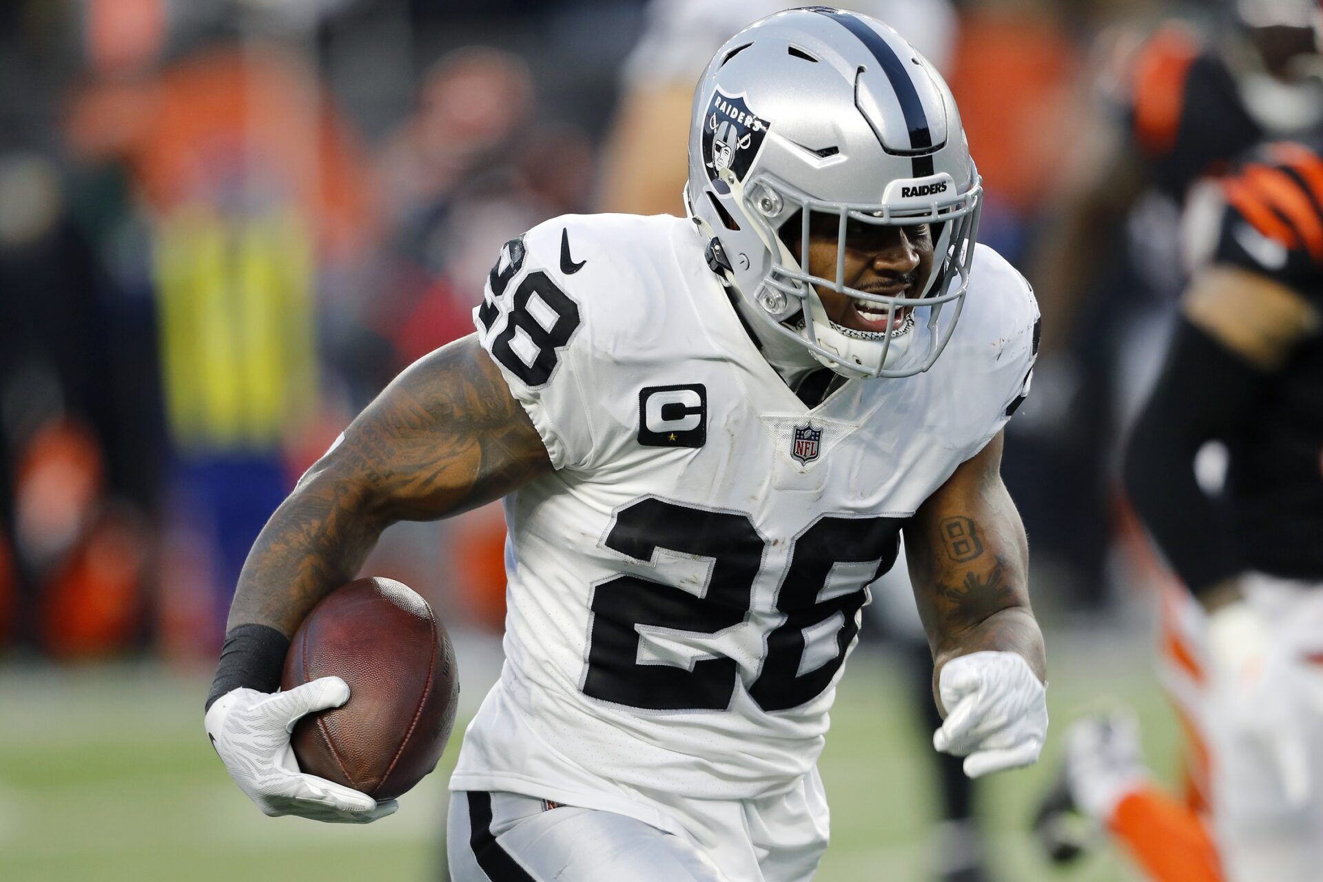 Josh Jacobs (28) runs during the second quarter in an AFC Wild Card playoff football game against the Cincinnati Bengals at Paul Brown Stadium.