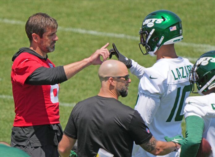 New York Jets QB Aaron Rodgers and WR Allen Lazard forge a handshake on the sidelines during Jets minicamp.