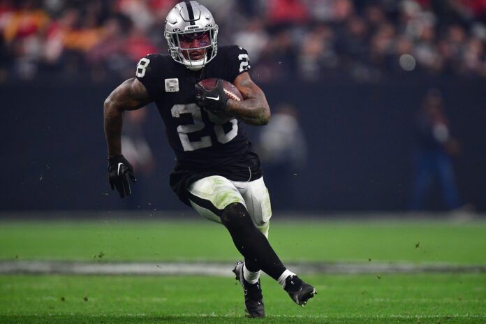 Josh Jacobs carries the ball.