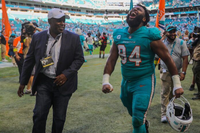 Miami Dolphins DT Christian Wilkins (94) celebrates after beating the New York Jets as GM Chris Grier looks on.