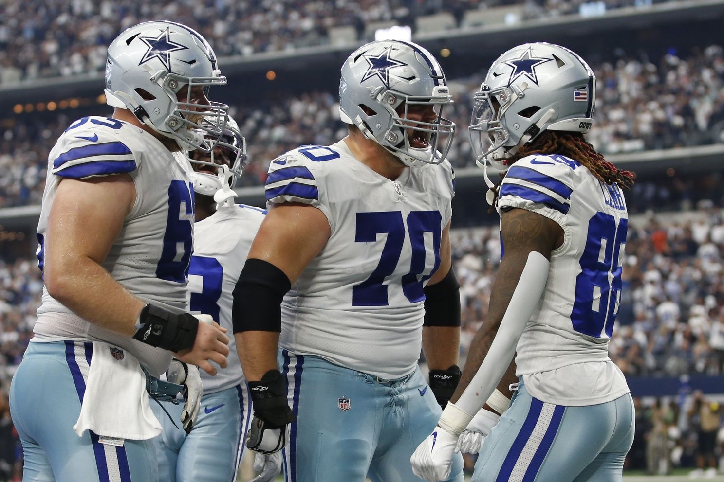 Dallas Cowboys OL Zack Martin (70) and Tyler Biadasz (63) celebrate with WR CeeDee Lamb (88) after a touchdown.