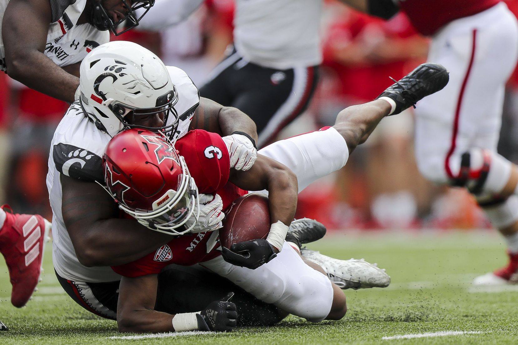 Cincinnati Bearcats DT Jowon Briggs (18) tackles Miami RedHawks RB Keyon Mozee (3).