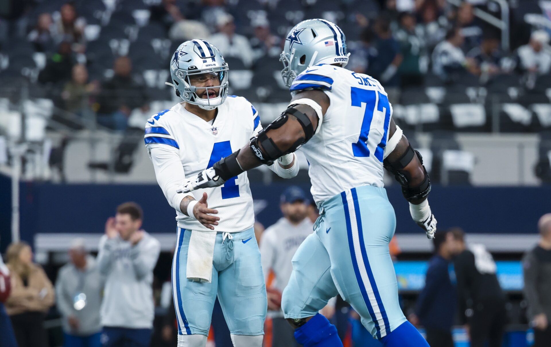 Dak Prescott (4) greets offensive tackle Tyron Smith (77) before the game against the Philadelphia Eagles at AT&T Stadium.