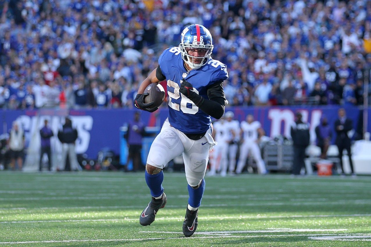 Saquon Barkley (26) runs with the ball against the Baltimore Ravens during the fourth quarter at MetLife Stadium.