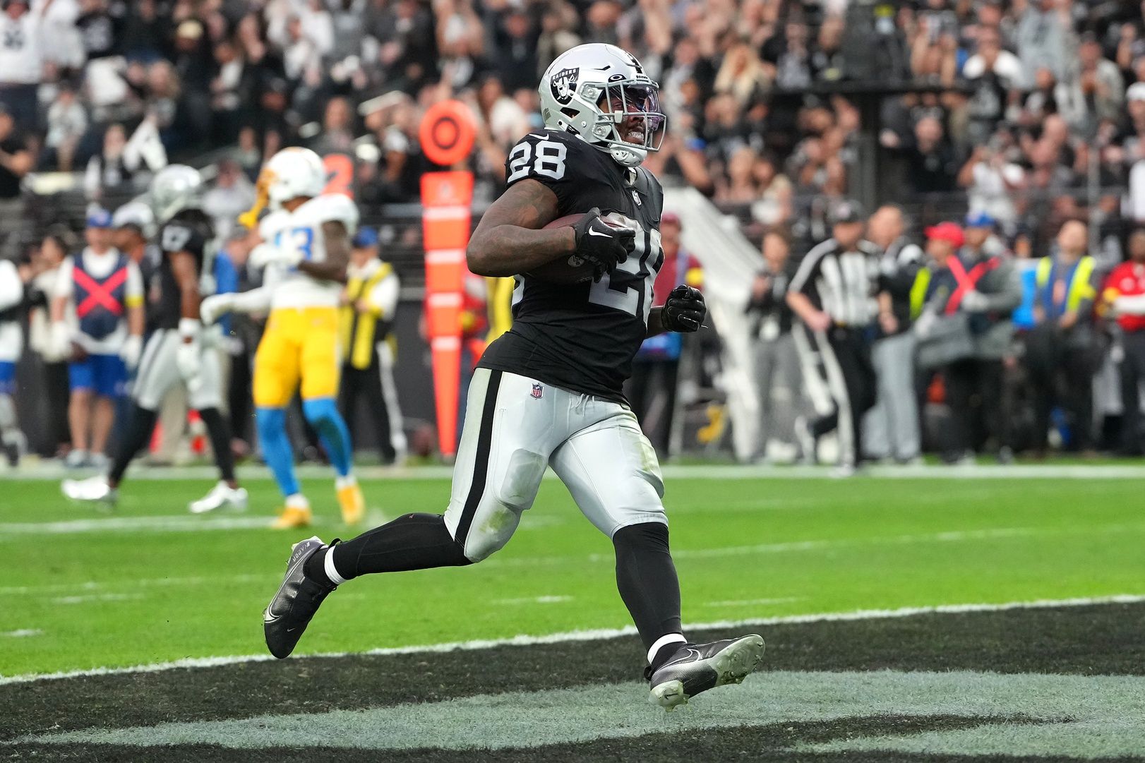 Josh Jacobs (28) scores a touchdown against the Los Angeles Chargers during the first half at Allegiant Stadium.