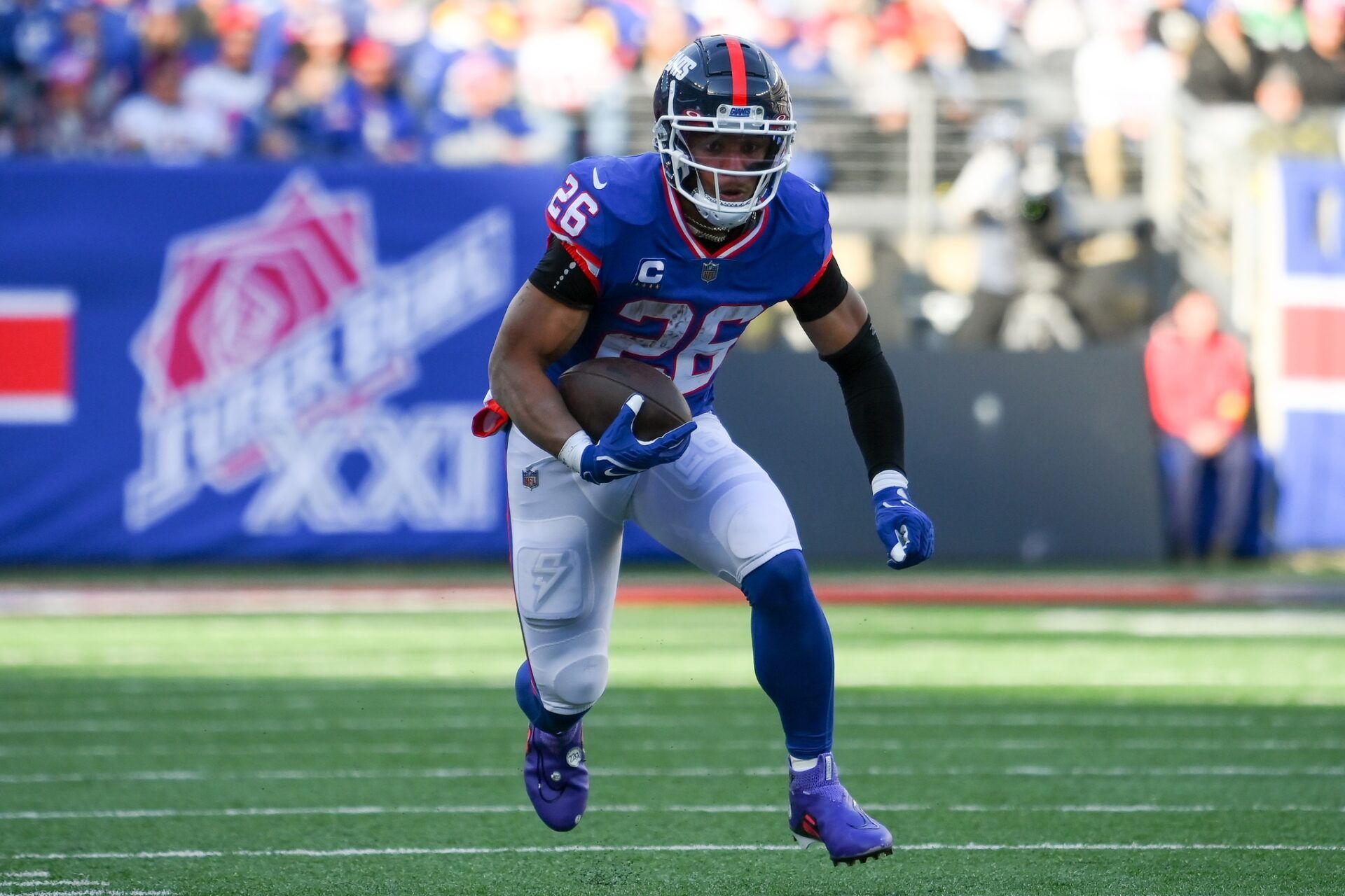 Saquon Barkley (26) runs with the ball against the Washington Commanders during the first half at MetLife Stadium.