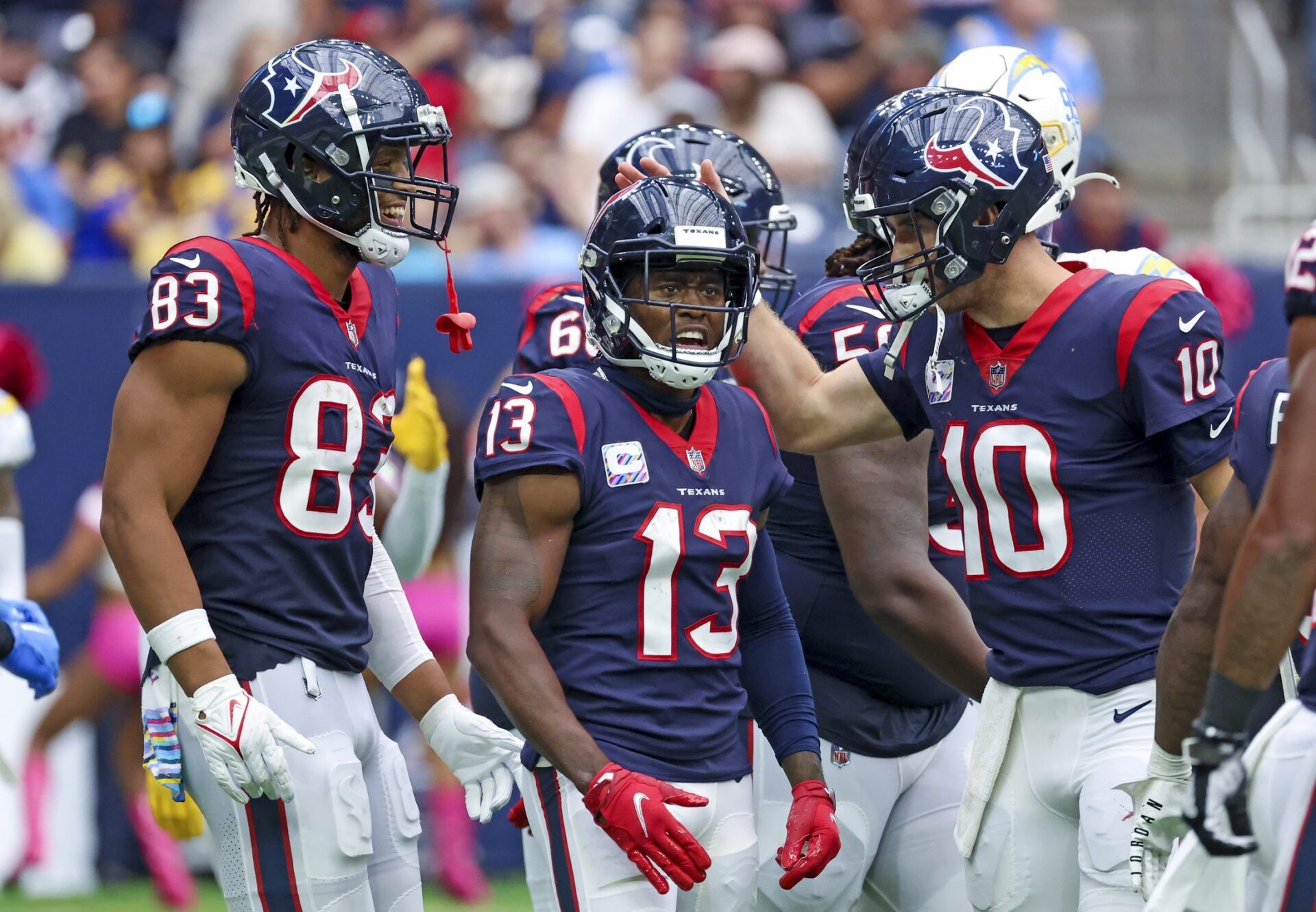 Brandin Cooks (13) celebrates with Houston Texans tight end O.J. Howard (83) and Houston Texans quarterback Davis Mills (10) after scoring a touchdown during the second half against the Los Angeles Chargers at NRG Stadium.