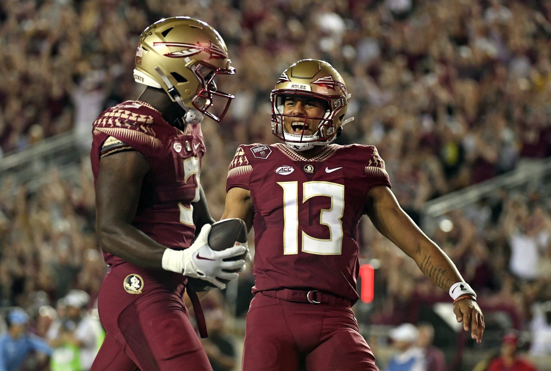 Trey Benson (3) celebrates with quarterback Jordan Travis (13) after scoring a touchdown against the Boston College Eagles during the first half at Doak S. Campbell Stadium.