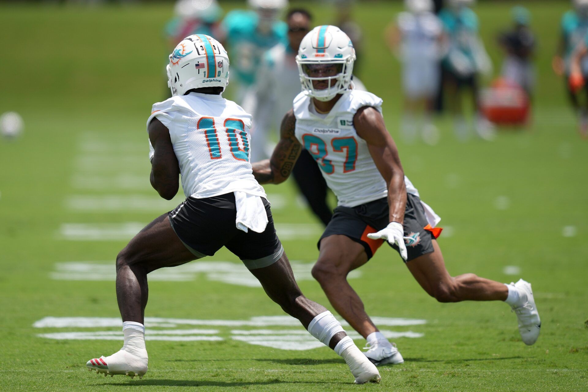 Tyreek Hill (10) runs a drill around wide receiver Erik Ezukanma (87) during OTA practice at Baptist Health Training Complex.