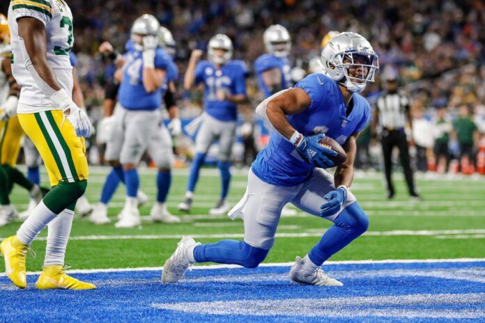 Detroit Lions WR Amon-Ra St. Brown (14) scores a touchdown against the Green Bay Packers.