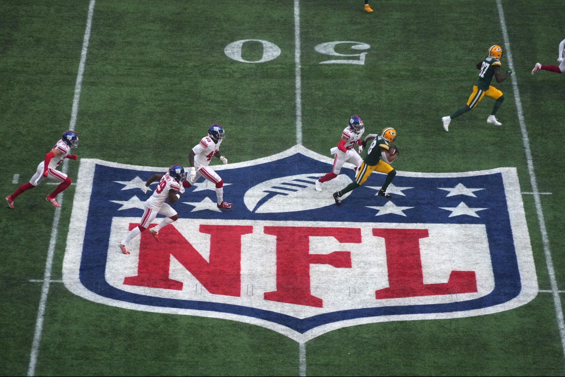 An aerial shot of the NFL logo while the Green Bay Packers and New York Giants play.